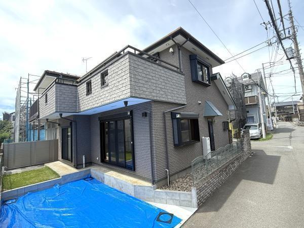 外観:青空に映える、洗練された中古戸建。落ち着いたタイル調の外観は美しさと耐久性を兼ね備え、カースペースも魅力です。手入れが行き届いた上質な住まいで、家族の新しい歴史を刻みませんか。